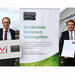 Wolfgang Saam und Thomas Bareiß (re.) mit der Mitglieds-Urkunde für Mayer-Kuvert-network (Bild: BMWi/Andreas Mertens)
