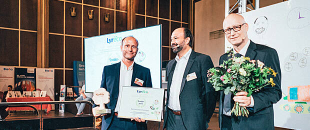 Michael Kirschner von der Barmenia Versicherung nimmt den Nachhaltigkeitspreis von Marc Gebauer und Olaf Dubbert (beide Lyreco) entgegen. Foto: Joshua A. Hoffmann
